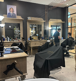 Davilia Location - Karrinyup's interior with wooden styling stations, and a barber cutting a client’s hair.