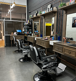 Davilia Location—Subiaco has a interior with black leather barber chairs, mirrors, hair tools, and product shelves