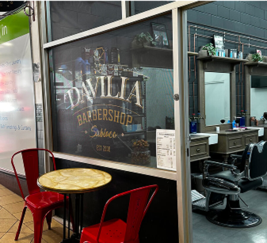 An inviting Davilia Barber Shop interior with a table and chairs arranged for clients.