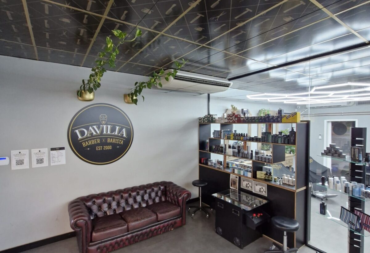 Davilia Barbershop in Duncraig with brown leather sofa, patterned ceiling, and product shelf with stools